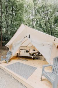 海伦Timberline Glamping at Unicoi State Park的帆布帐篷 - 带2把椅子和1张床