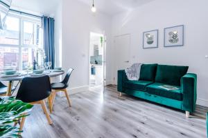 克鲁Spacious 4-bed house in Crewe by 53 Degrees Property, ideal for Business & Contractors - Sleeps 7的客厅配有绿色沙发和桌子
