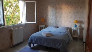 圣埃尔布兰Chambre et sdb privées avec accès indépendant et autonome的一间卧室配有一张带两张桌子和一扇窗户的床。