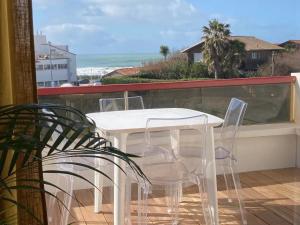 比亚里茨Milady Ocean View的阳台上配有白色的桌椅,享有海景