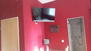 普福尔茨海姆Gasthaus Krone的一间在红色墙壁上配有电视的浴室