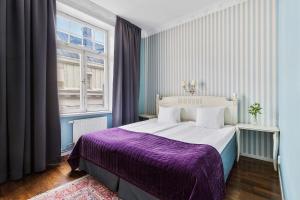 斯德哥尔摩本特利贝斯特韦斯特酒店的一间卧室配有一张大床和紫色毯子