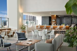 迈阿密YOTELPAD Miami的一间设有白色桌椅的餐厅和一间酒吧