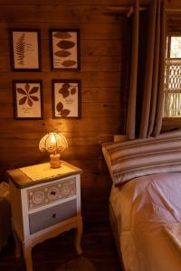 梅尔戈佐Eco-Resort Parco Botanico Fiorlago的一间卧室配有一张床和一张带台灯的桌子
