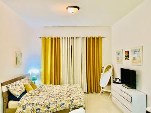 拉斯阿尔卡麦Rixos Beach Apartment的一间卧室配有床和黄色窗帘