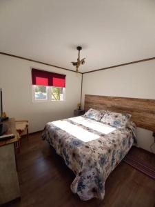 蓬塔阿雷纳斯Cabañas Altos de Leñadura的一间卧室配有一张大床和木制床头板