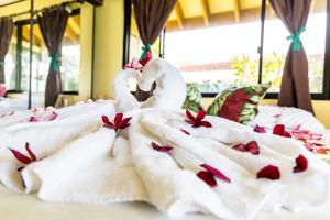 波拉波拉Fare Manava的两个天鹅在床上,玫瑰花在床上