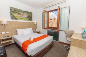 库斯科安迪纳之标准库斯科广场酒店的配有一张床、一张书桌和一扇窗户的酒店客房