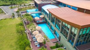 济州市樟树酒店及度假村 的享有带游泳池和遮阳伞的度假村的顶部景致