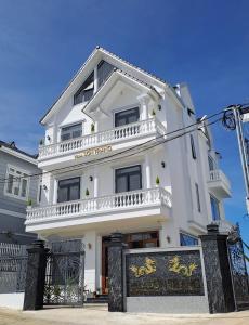 大叻Uncle Park's Villa Son Trang 엉클팍的前面有标志的白色建筑