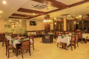 巴拉特布尔Bharatpur Garden Resort的餐厅内带桌椅的用餐室