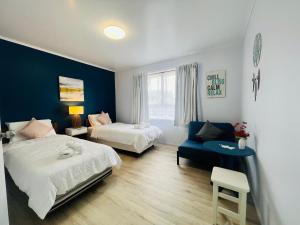 汉密尔顿La Sol - All you need for a stay, close to town, University & Cambridge的一间卧室设有两张床和蓝色的墙壁