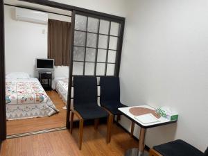 大阪Marunishi的小房间设有一张床、一张桌子和椅子