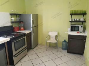 圣卡洛斯Casa Tecalai 5的厨房配有冰箱、炉灶和椅子