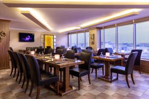 Al WakrahWakra Inn Hotel Apartments的餐厅设有桌椅和大窗户。