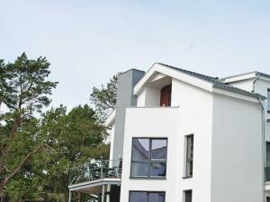 巴贝Strandvilla Baabe - Maisonette "Sonnenwiege" mit Sauna und Whirlpool的白色房子的一侧设有阳台