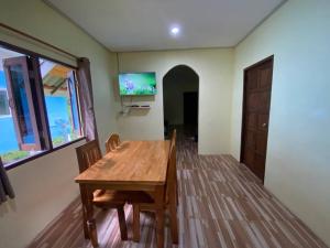 阁遥岛2 Bed Sunset Seaview Good View House Y的一间带木桌和椅子的用餐室