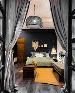爱妮岛El Nido Boutique Vacation Villas的一间卧室配有一张床、一张桌子和窗帘