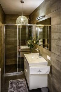 卡尔帕奇Apartamenty Alcatraz z Jacuzzi的浴室设有白色水槽和镜子