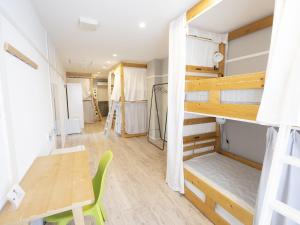 名古屋Usatsuno Osu的客房设有一张桌子和一张双层床。