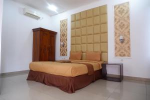 Wonosari歌利亚丽曼山古农齐都尔旅馆的一间卧室配有一张大床和大床头板