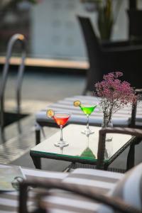河内HÔTEL De SOURIANT Premium Hanoi的一张桌子,上面有两杯眼镜,花瓶