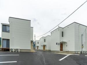佐世保Rakuten STAY HOUSE x WILL STYLE Sasebo 110的街道上一排白色的建筑