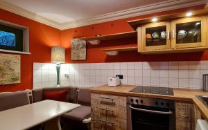 库洛特拉森Art-House Kurort Rathen的厨房设有橙色墙壁和炉灶烤箱