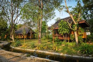 拜县Baan Krating Pai Resort - SHA Plus的丛林中的房屋,前面有池塘