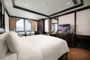 河内HÔTEL De SOURIANT Premium Hanoi的卧室配有一张白色大床和电视。