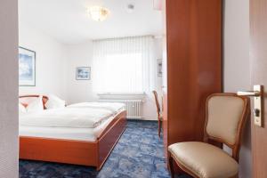 霍尔茨维克德TM Hotel Dortmund Airport的配有一张床和一把椅子的酒店客房