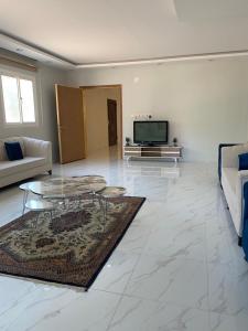 欧拉شاليه الجبل الاحمر 3的客厅配有桌子和电视