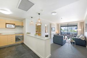 达尔文Exclusive Resort-style Living with Balcony & Pool的厨房以及带沙发和桌子的客厅。