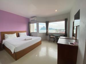 班武里府巴蜀海滩酒店的一间卧室配有一张床和一张桌子,享有美景