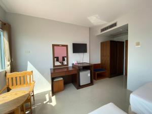 班武里府巴蜀海滩酒店的一间卧室配有一张带镜子的桌子和一台电视机