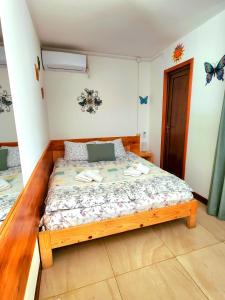 乌雷基House & Yard Sesil XS 60m to beach的卧室配有木床,卧室的墙上挂着蝴蝶。