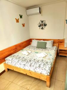 乌雷基House & Yard Sesil XS 60m to beach的卧室配有一张床,卧室位于墙上,墙上挂着蝴蝶。
