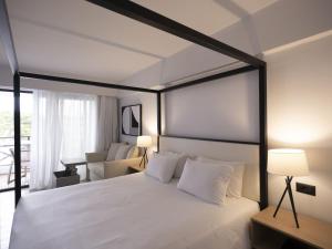 赫索尼索斯赫索尼索斯皇庭酒店的一间卧室配有一张黑色框架的白色床