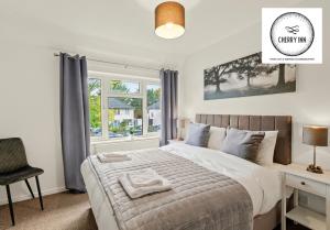 剑桥Large 3 Bedroom House with Parking & Garden by Cherry Inn Short Let's & Services Accomodation的一间卧室配有一张床、一张书桌和一个窗户。