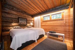 鲁卡Keloruka 15 luxury lodge, 5 ensuite bedrooms, 250 m2, jacuzzi, 2 x ski pass的小木屋内一间卧室,配有两张床