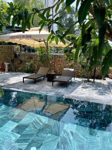 芽庄Garden House Nha Trang的一个带两把椅子和一张桌子的游泳池