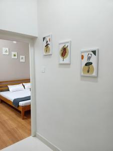 马杜赖Meadows Homestay的卧室配有一张床,墙上挂有图片