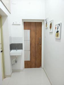 马杜赖Meadows Homestay的一间带木门和水槽的浴室