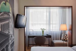 伯尔尼拉裴格拉伯尔尼酒店的酒店客房设有一张床、一台电视和一扇窗户。