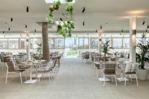 蒂加基Utopia Blu Hotel的用餐室设有桌椅和窗户。