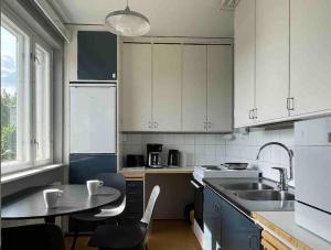 拉彭兰塔Studiohuoneisto Liisankatu的厨房配有白色橱柜、桌子和水槽。