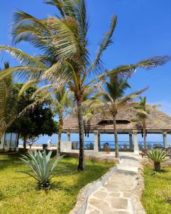 瓦塔穆Mawe Zuri Resort的海滩旁的棕榈树,设有凉亭