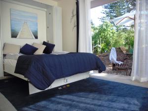 欧尼罗亚蓝鸟旅馆的一间卧室设有一张床和一个大窗户