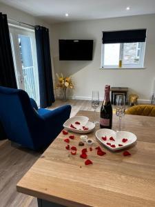 阿尔弗斯顿Ulverston stunning 1 bedroom apartment的一张桌子,上面放着一瓶葡萄酒和红心