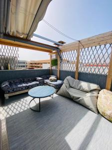 科拉雷侯Golden Wave Surf Roof Terrace的一间配有沙发和一张桌子的阳台客房